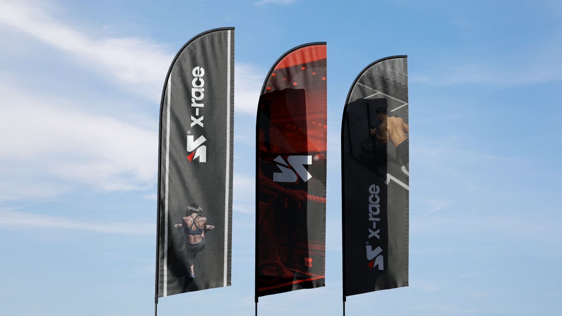 Tres banderas X-RACE de tela contra el cielo