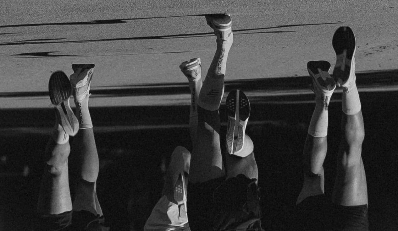 Piernas de un grupo de corredores en plena carrera, en blanco y negro