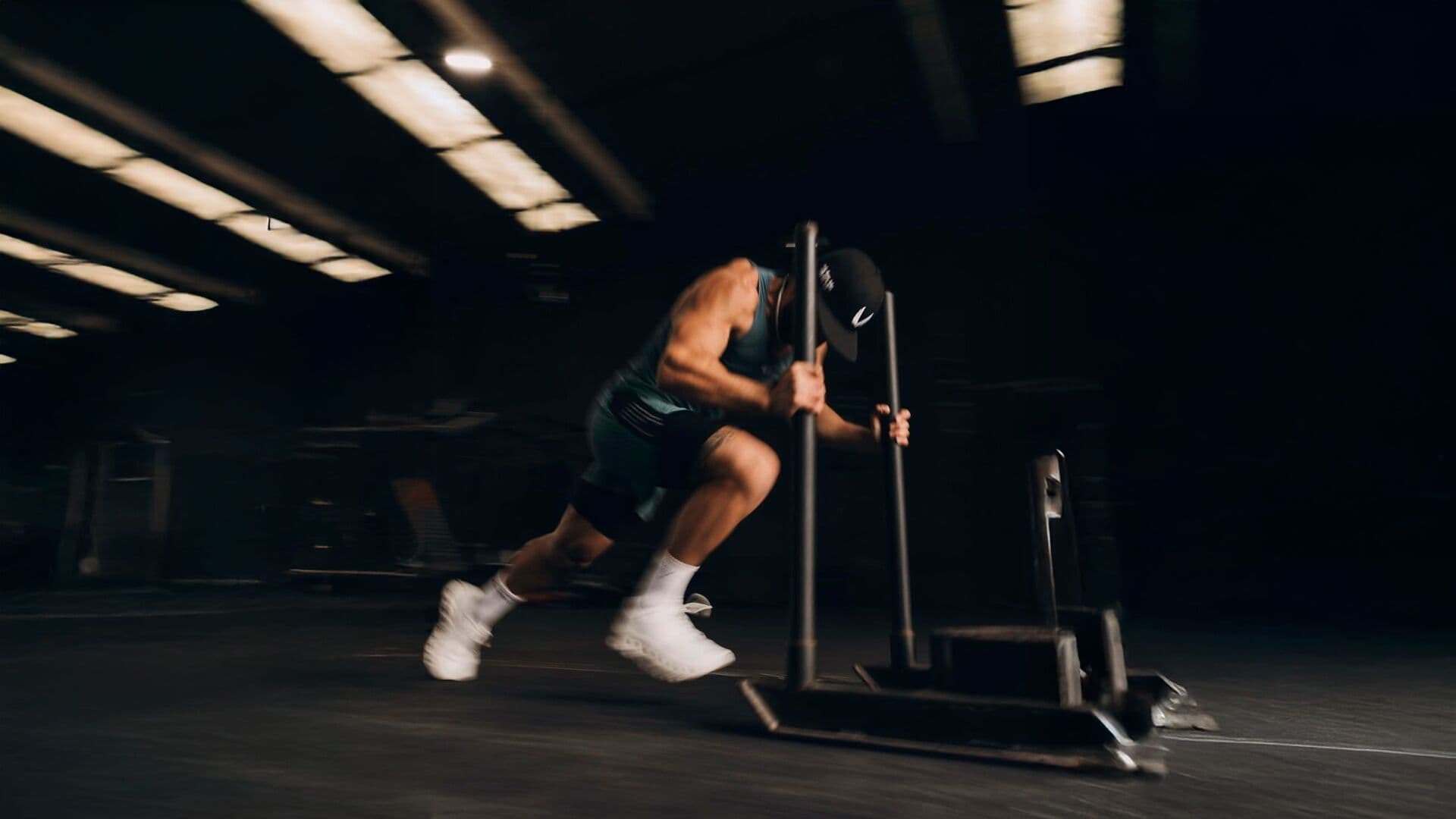 Atleta empujando un trineo con carga en un gimnasio